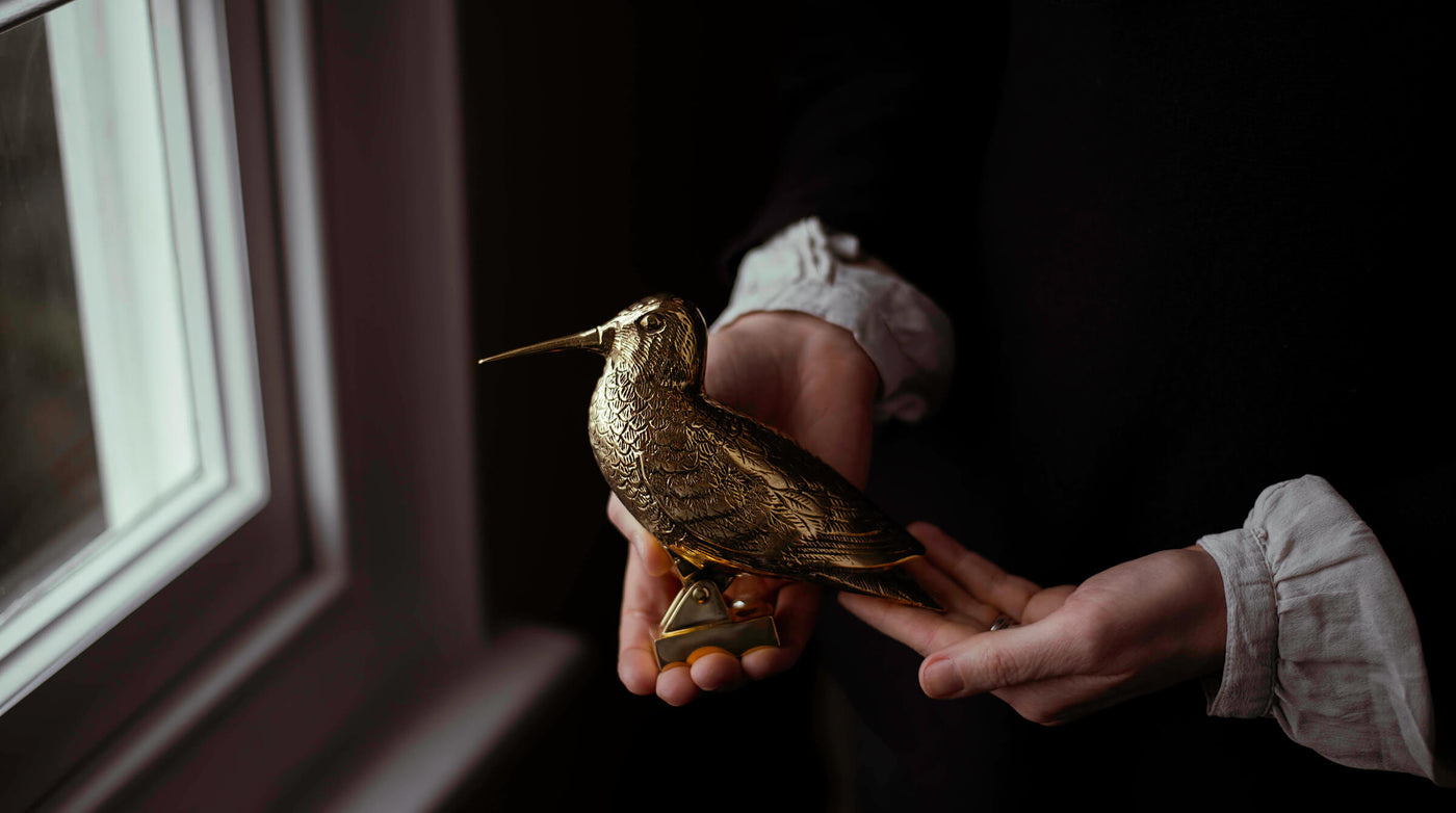 Bird door knocker in solid brass held in hands