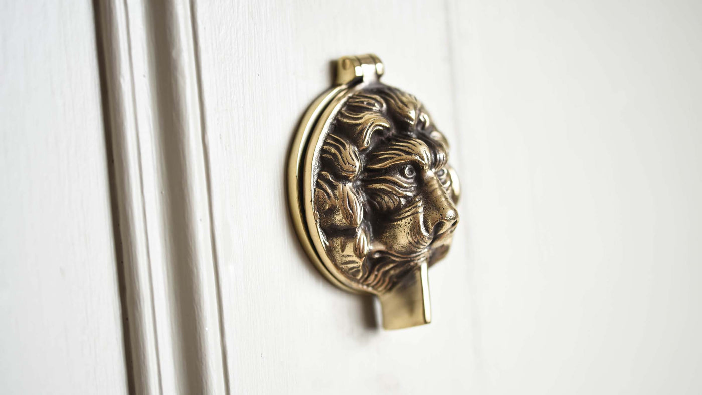 Aged Brass Lions Head Latch Cover on Door
