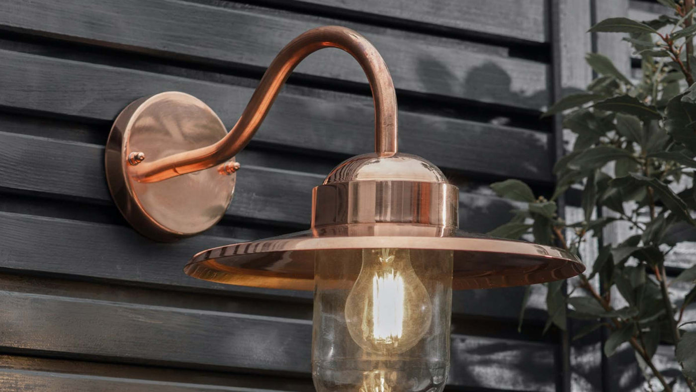 Copper wall light on wooden cladding