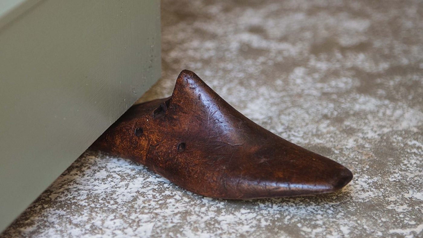 Upcycled Vintage shoe last used as a door stop wedging a door ajar