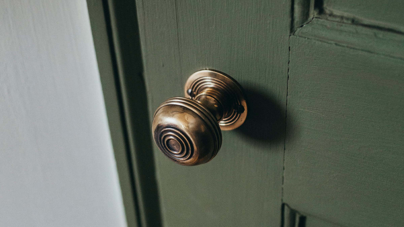 Brass Bloxwich Door Knobs on Green Door