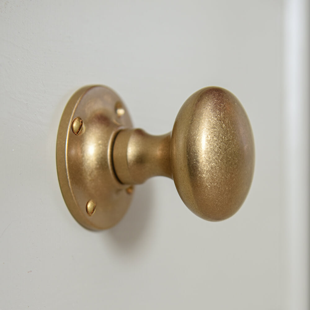 door knobs with a cushioned shape and aged brass finish