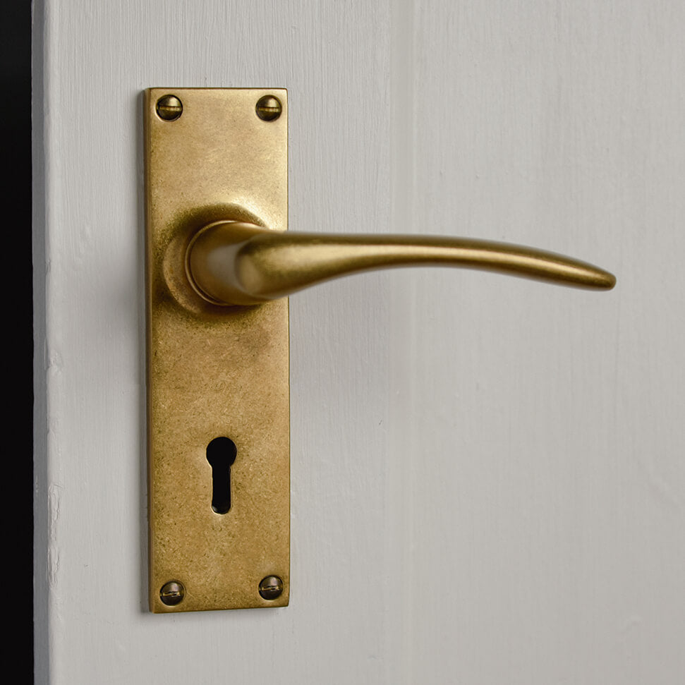 Aged brass lever handle on a neutral door