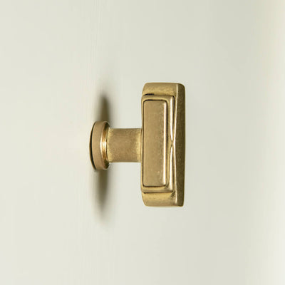 Shown in profile - Aged Brass Art Deco Cabinet Knob in a rectangular  design with reeded deco style edges