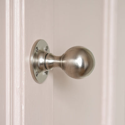 Satin nickel round door knobs on pink door