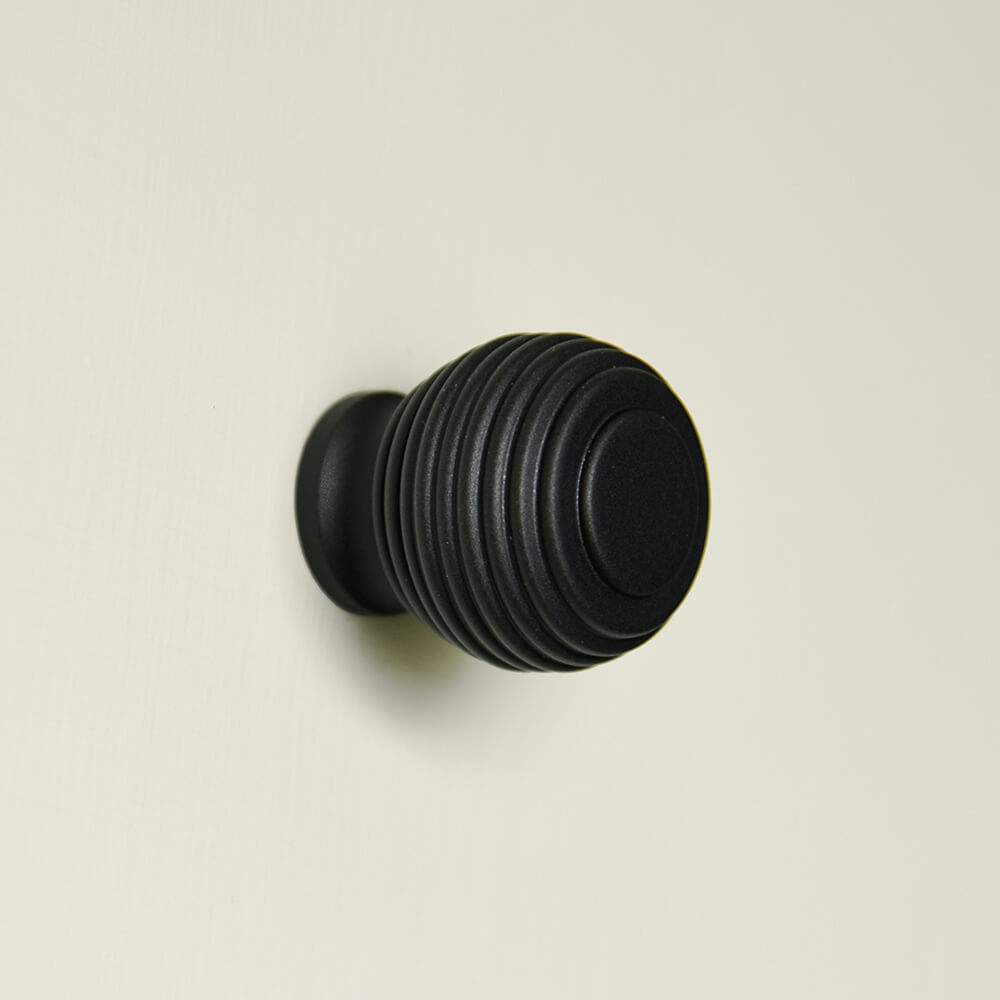 reeded balck cupboard handle on a cream background