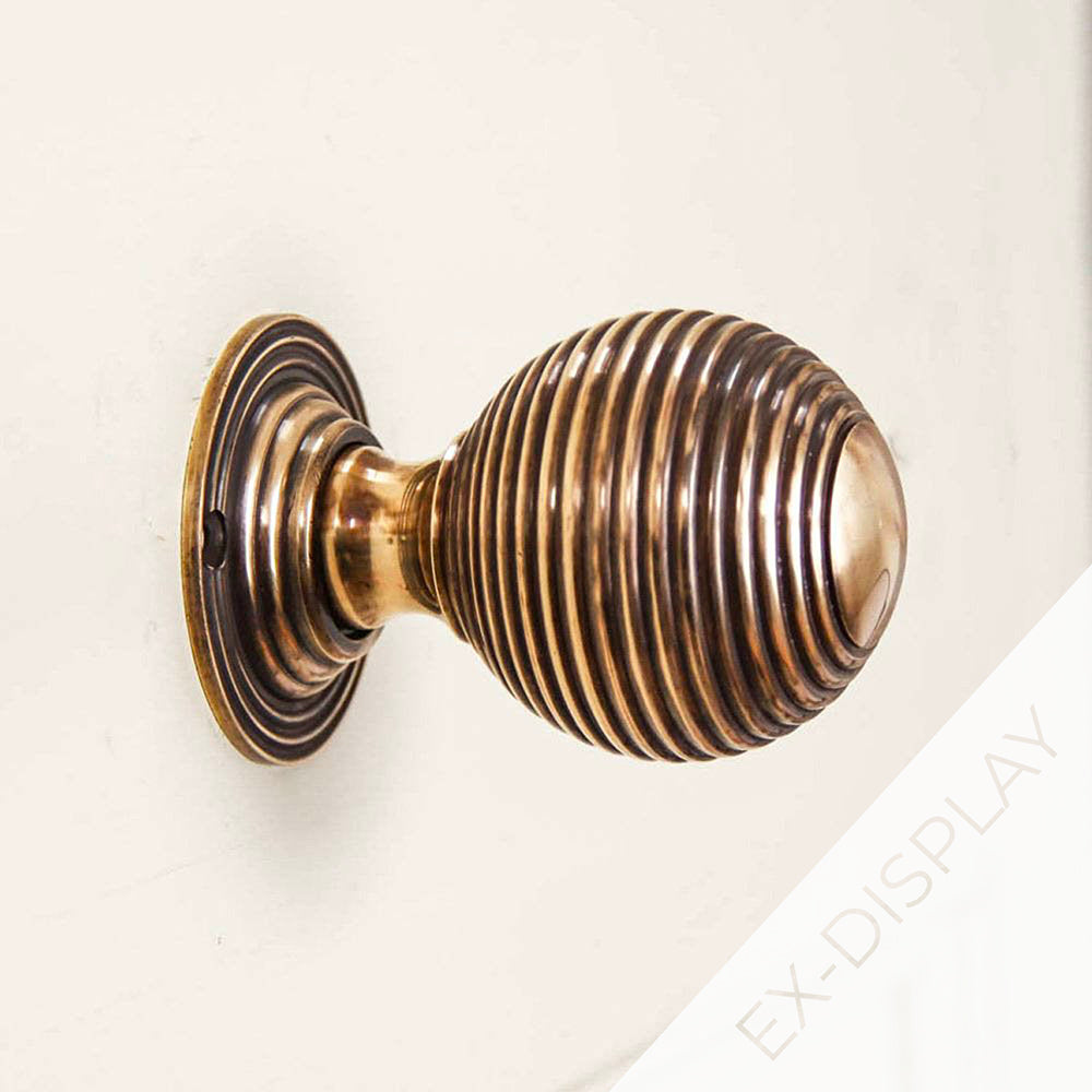 Polished antique brass large beehive door knob on a cream backgground with a watermark and ex-display text in the corner