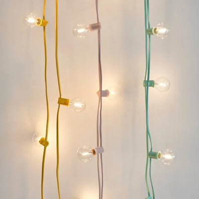 3 sets of festoon light hanging down from a wall with a pink, yellow and green cable 
