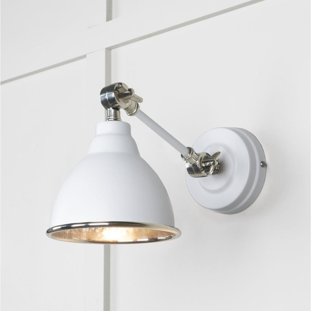 Hammered nickel Brindley wall light in ice white against a white panelled wall
