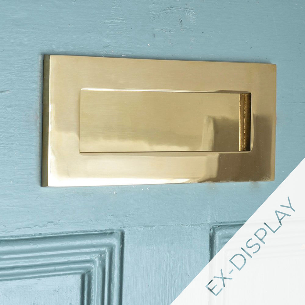 Polished brass front door letterplate on a blue door with a watermark and ex display text in the corner