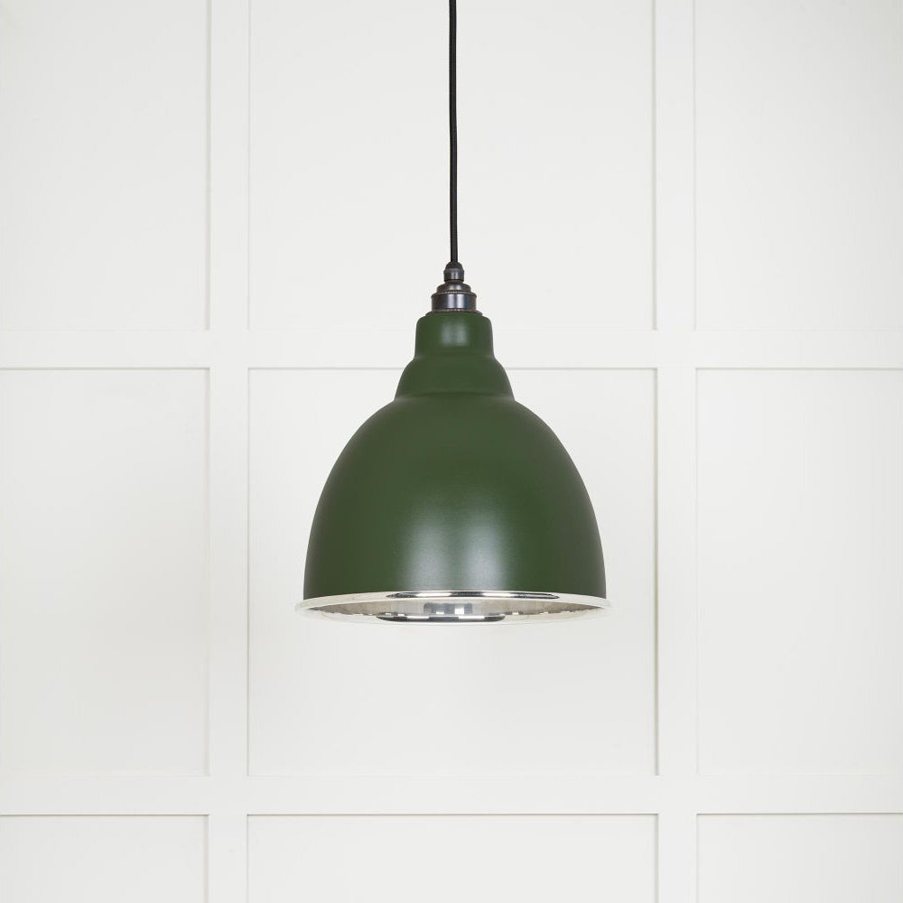 Smooth polished nickel Brindley pendant light with a powder coated finish in heath hanging from a black fabric cable against a white panelled wall
