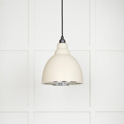 Smooth polished nickel Brindley pendant light with a powder coated finish in teasel hanging from a black fabric cable against a white panelled wall