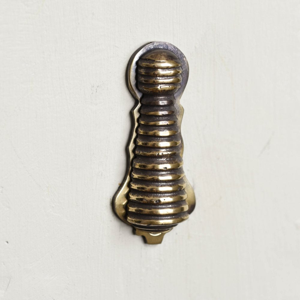 Aged brass reeded beehive escutcheon closed