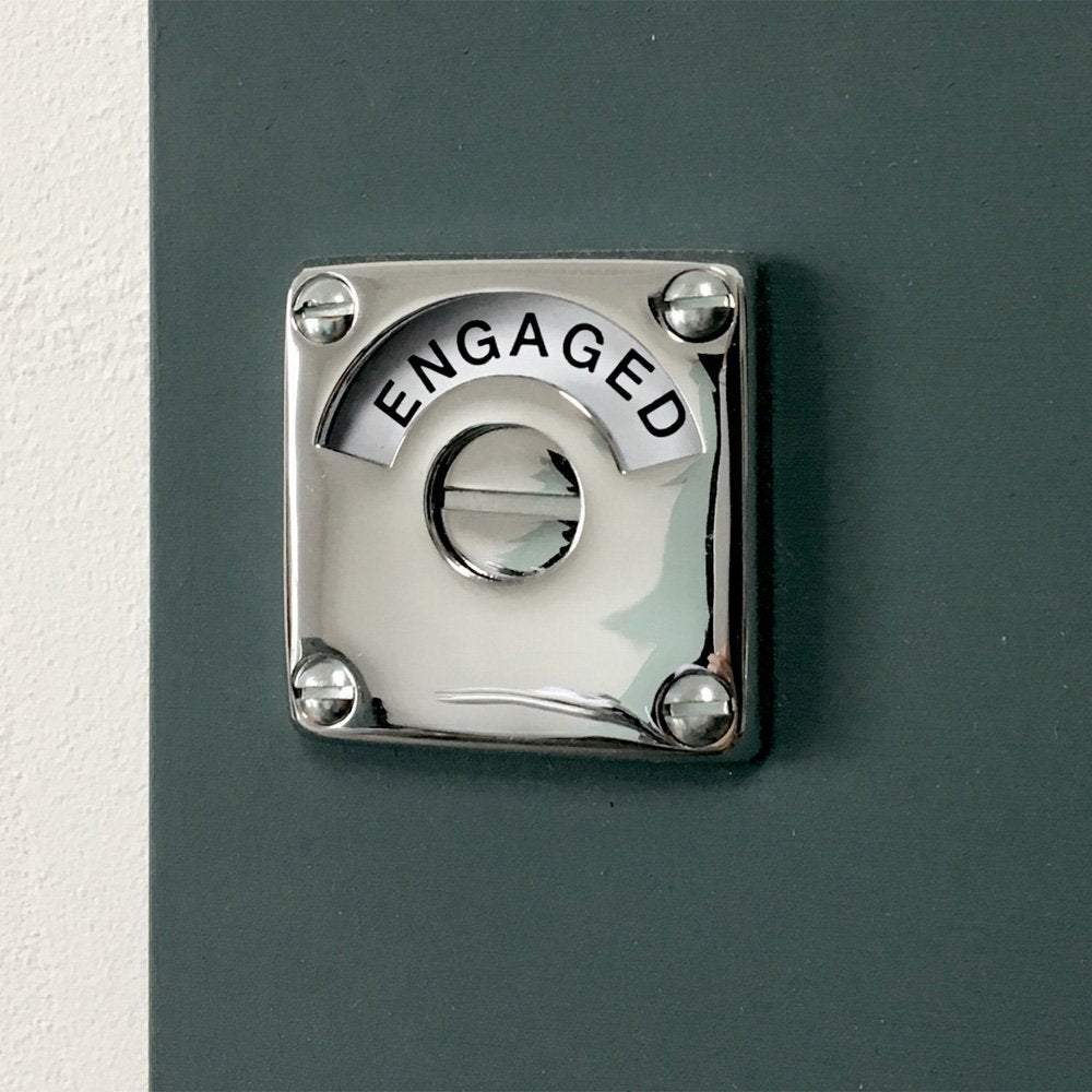 Square chrome bathroom door lock that says engaged when turned