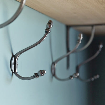 Natural Iron Double Coat Hook shown in a row beneath a shelf and matching brackets
