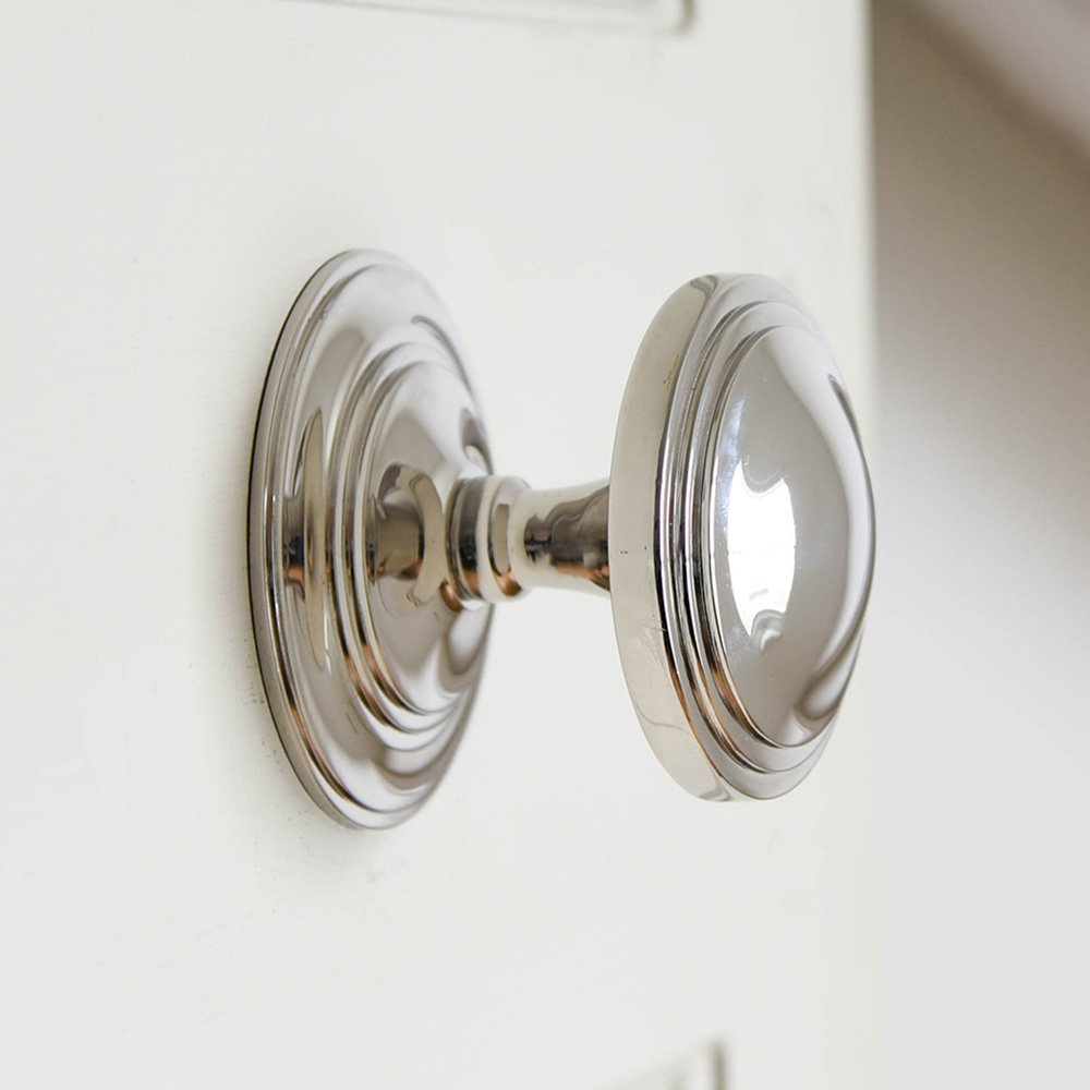 A round art deco style door pull in polished nickel