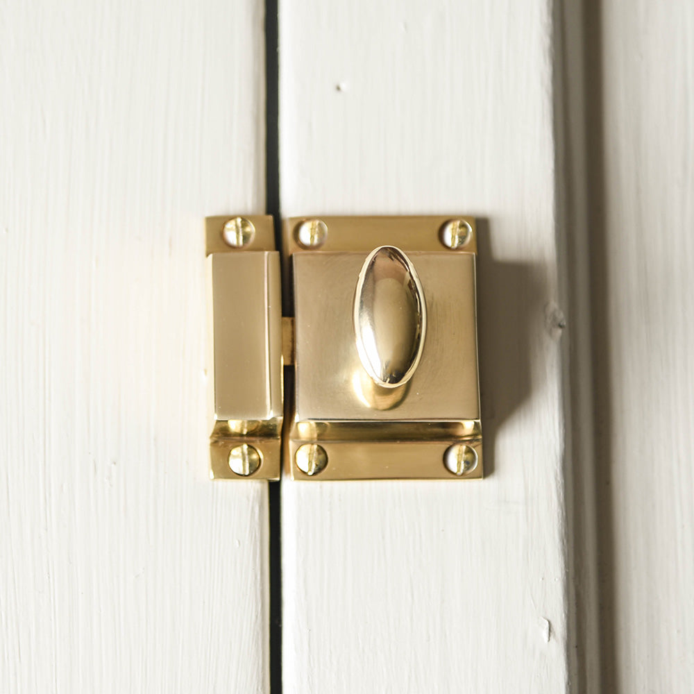 A detailed photo of the cupboard latch polished brass finish