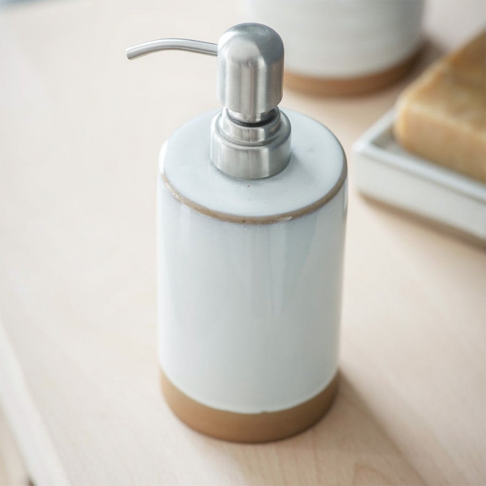 White ceramic soap dispenser with terracotta base