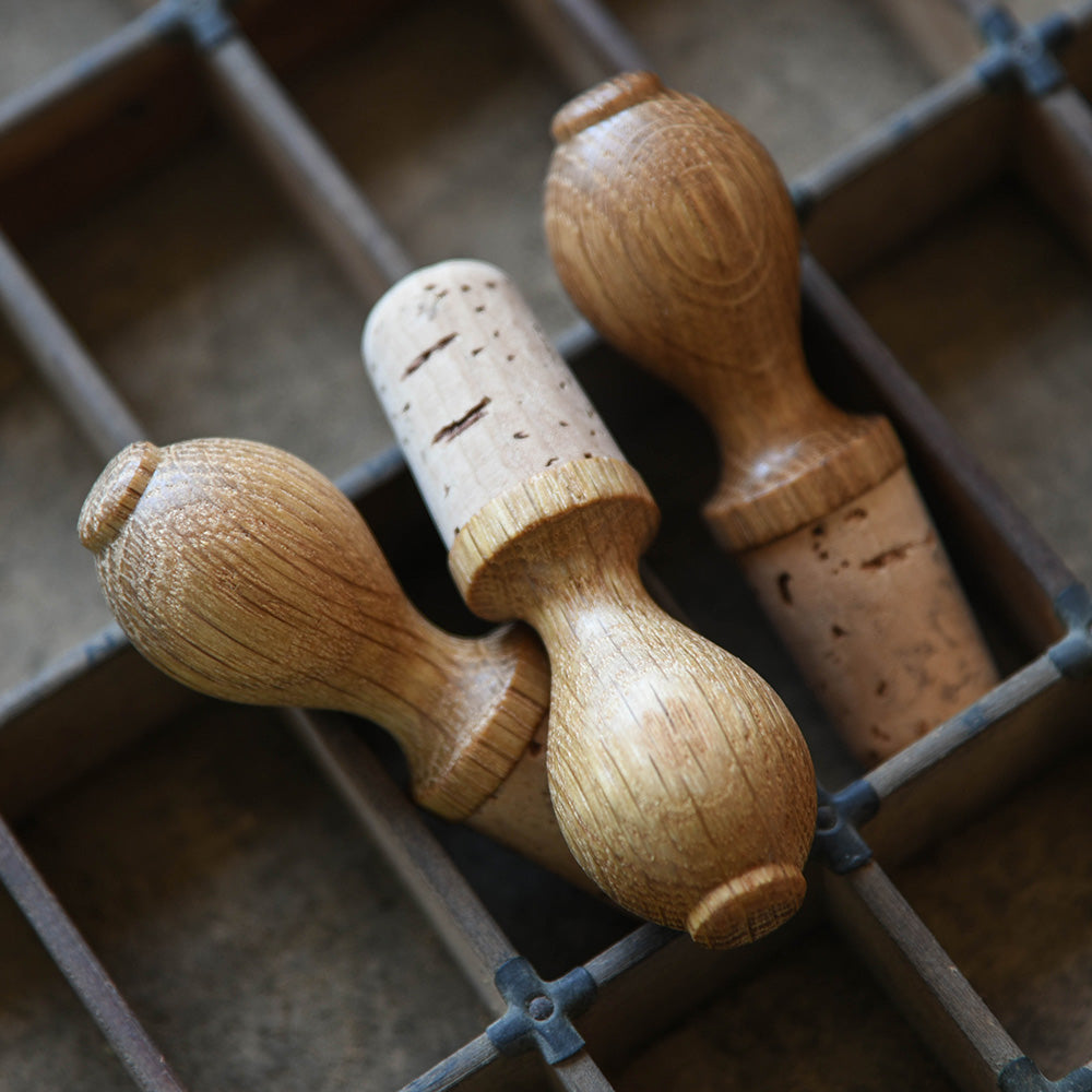 Wine bottle stopper with solid oak tops and cork stoppers