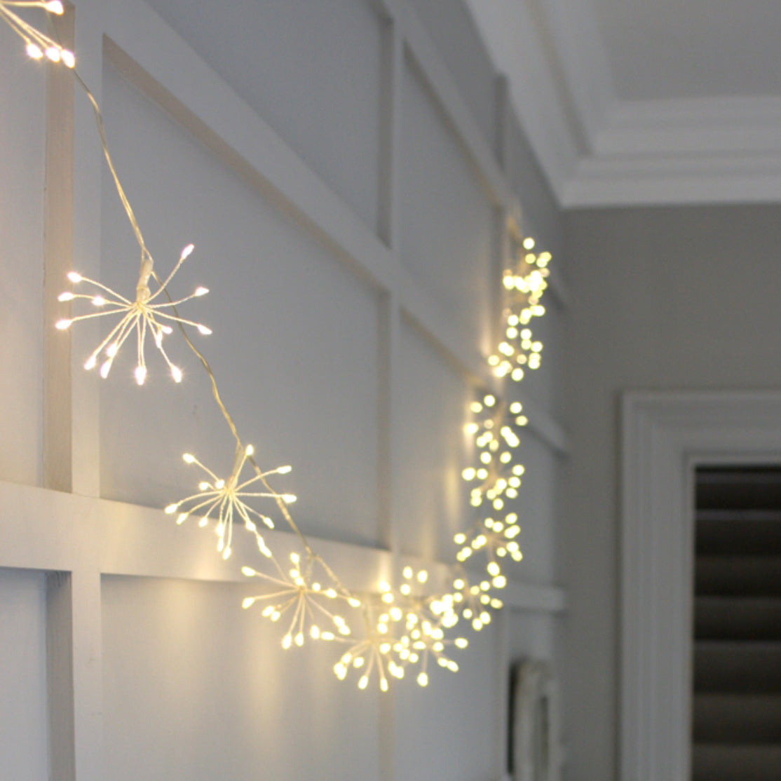 Chain of Silver Starburst LED Fairy Lights on Wall