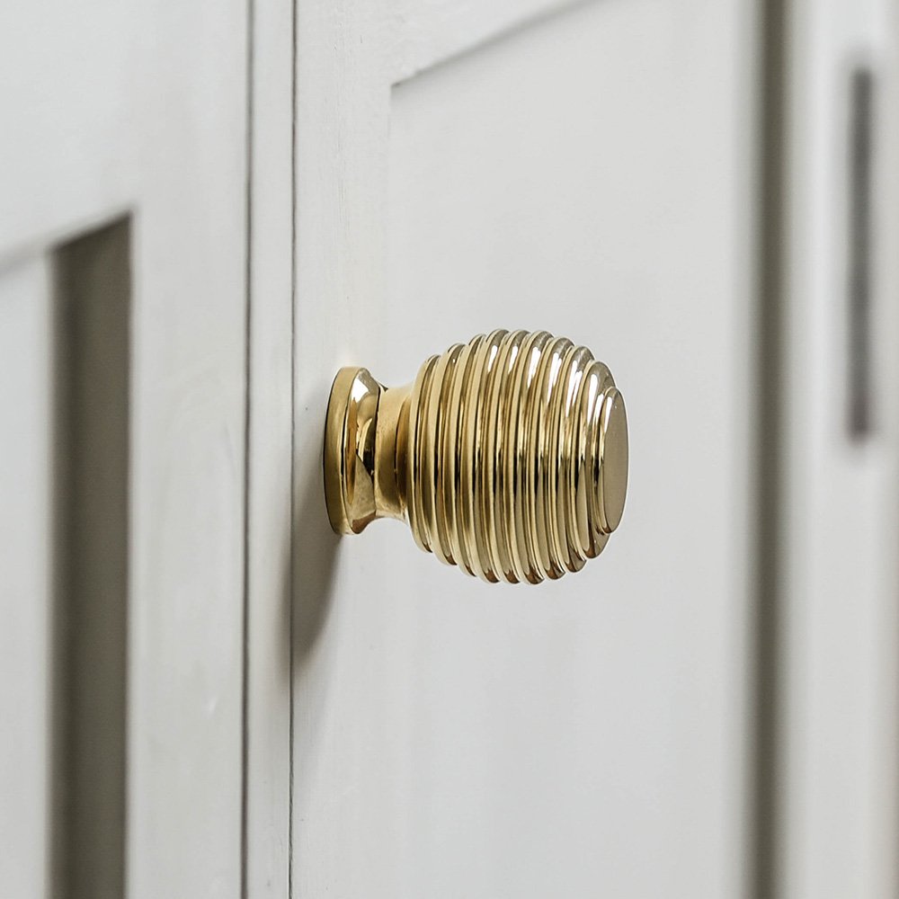 Queen Anne Beehive Cabinet Knob in Polished Brass on cupboard door.