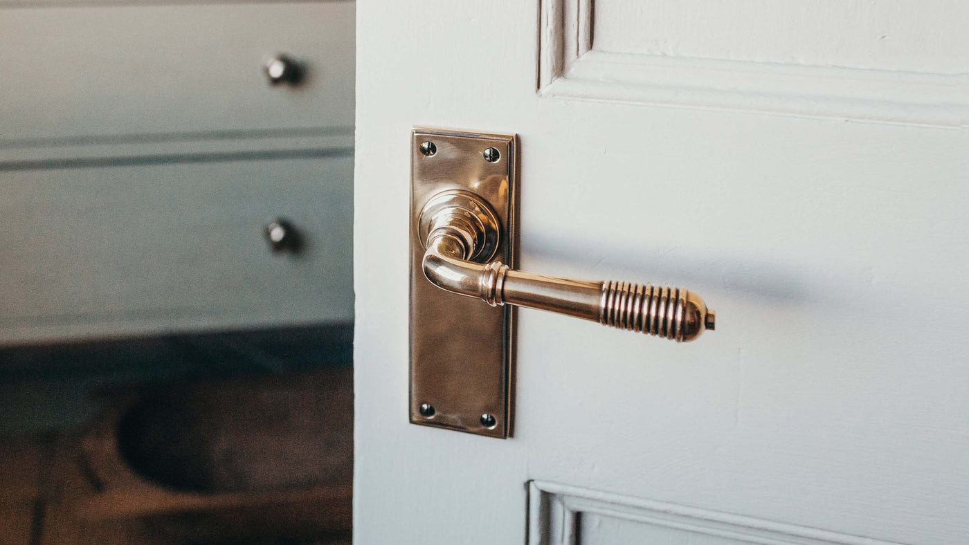 Brass reeded lever handle on door of bedroom