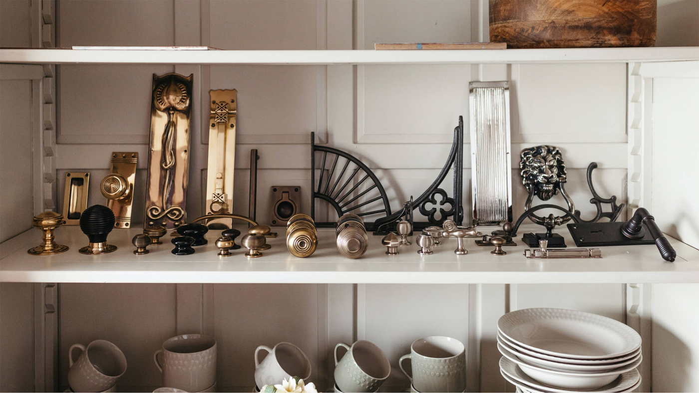 Shelf of architectural ironmongery in various finishes including brass, nickel and iron