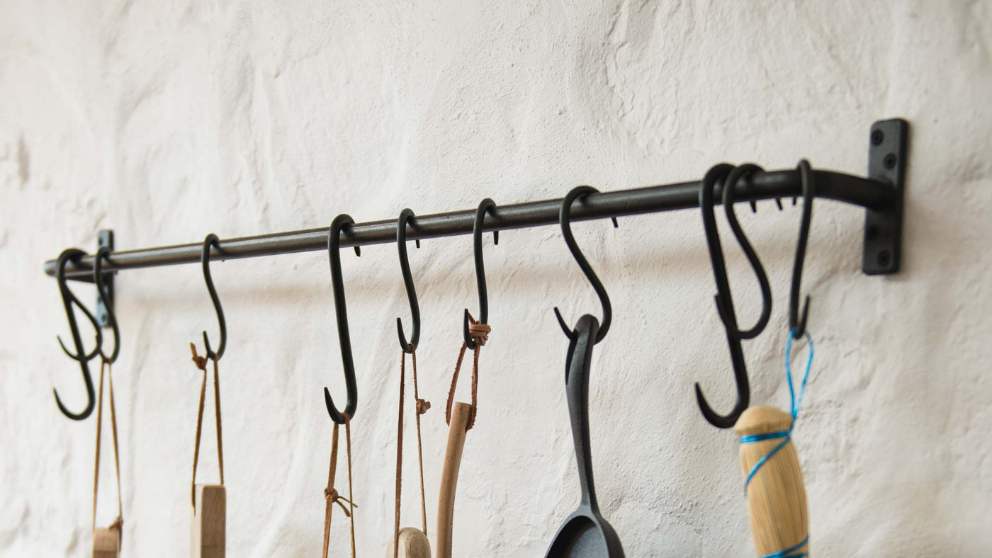 Kitchen Rail Storage with Fixtures and Hooks on a Kitchen wall holding pots and pans