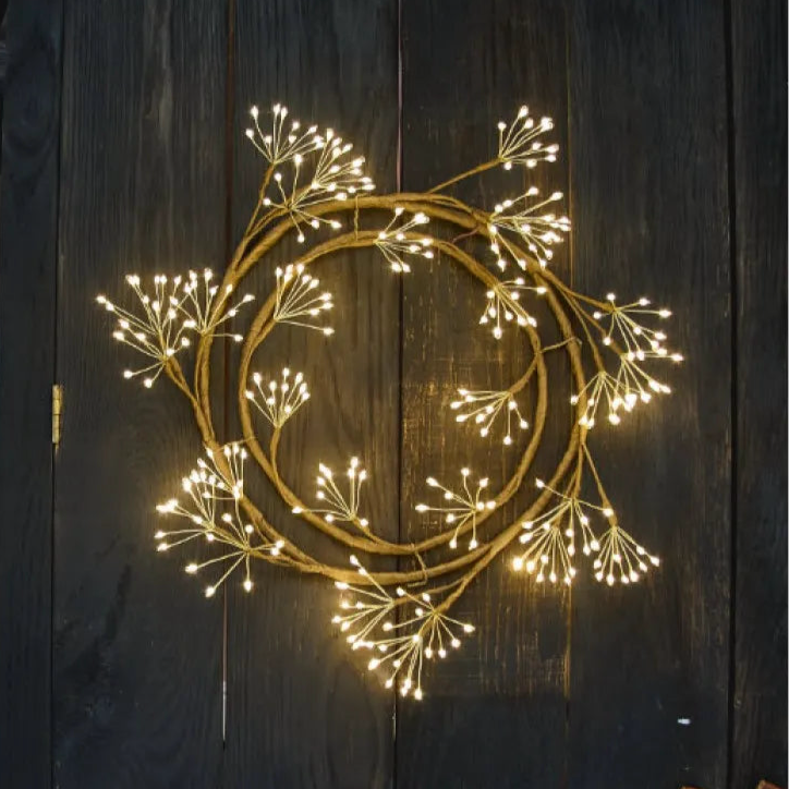 Fairy light wreath on wood background 