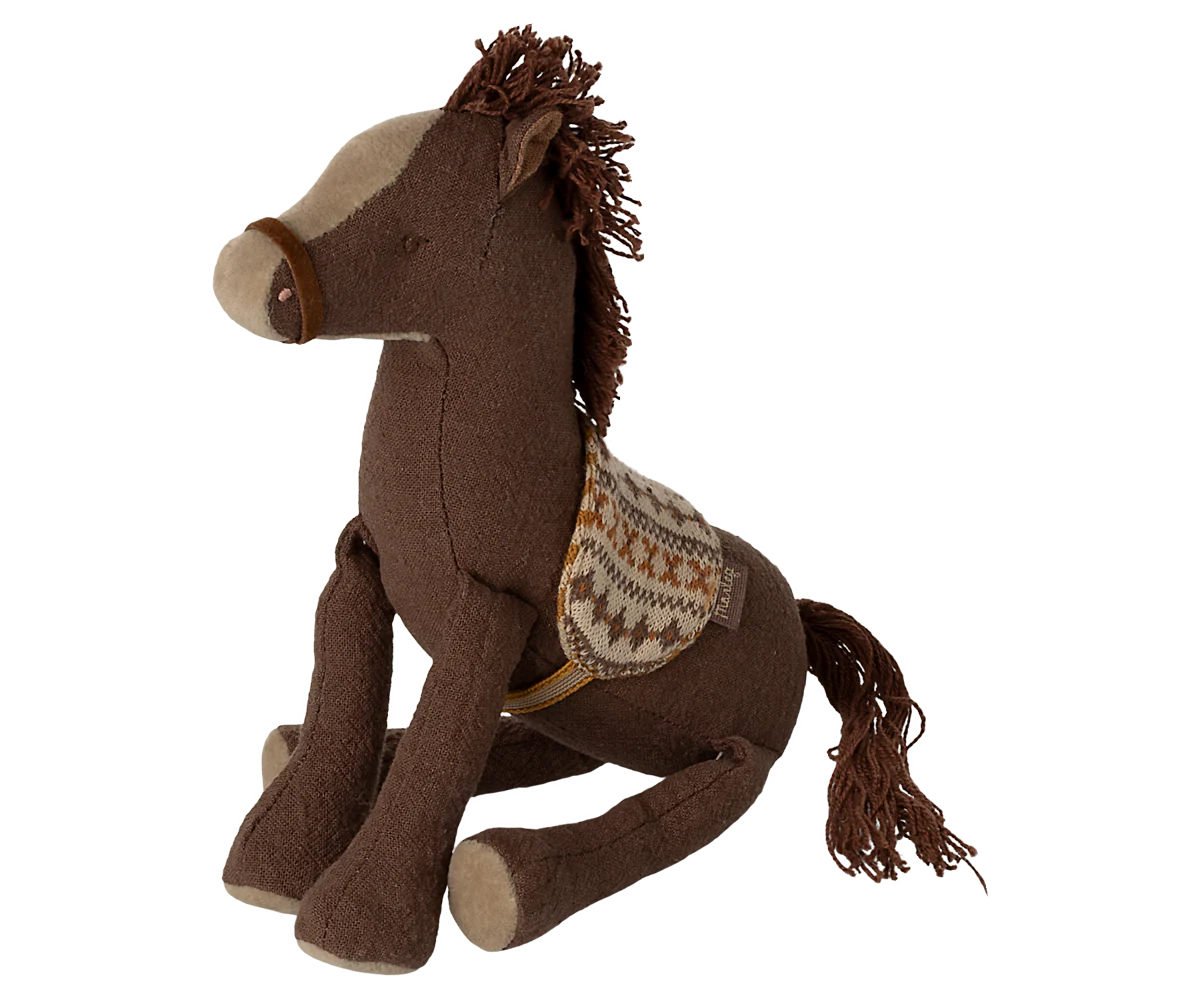 Brown plush horse toy with a saddle on a white background