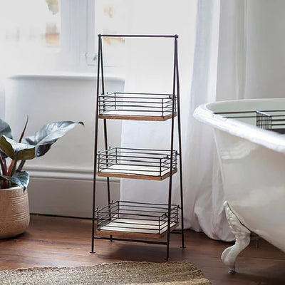Three tier bathroom caddy with iron frame and mango wood shelves in situ next to bath with empty shelves