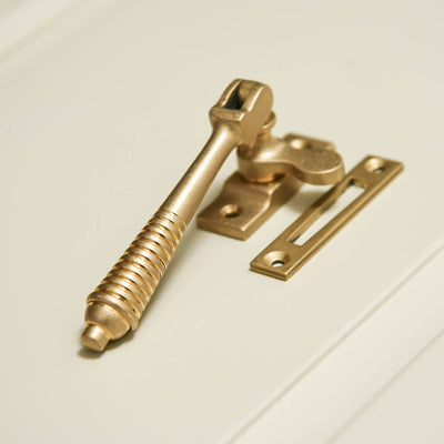 Brass casement fastener shown with its keep that sits on the window frame.
