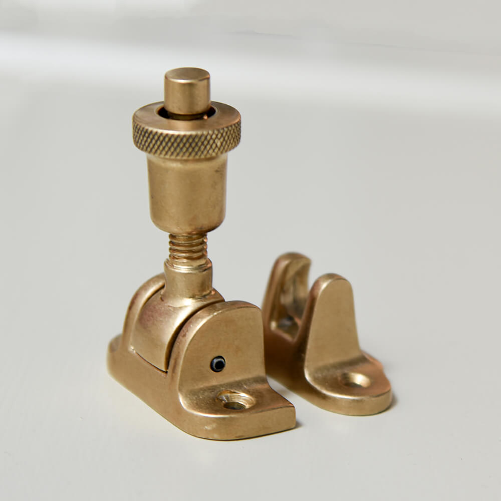 fastener for a window seen opened and with an aged dull brass finish