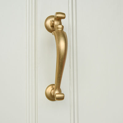 Brass door knocker on a white panelled door