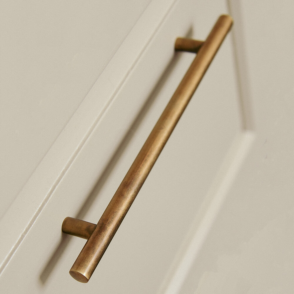 aged brass long plain pull handle on a drawr