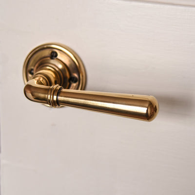 Aged brass lever handle on door