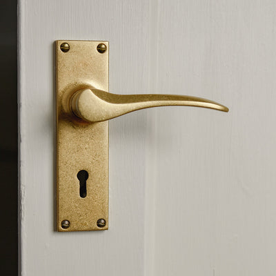 Aged Brass Penwerris Lever Lock Handles on a cream painted door