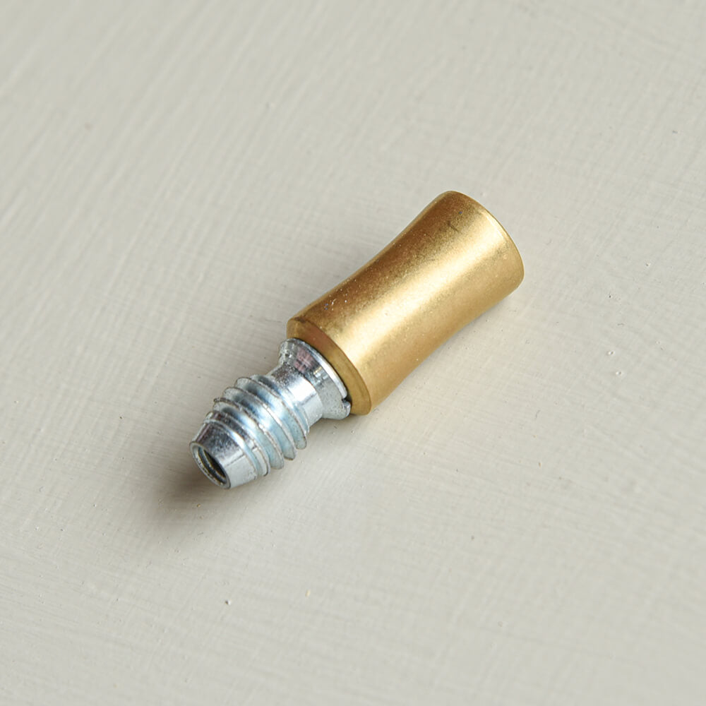 Brass threaded sash stop on a beige background