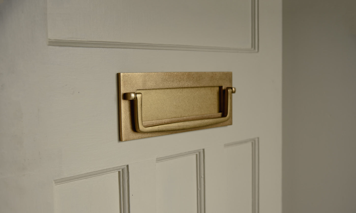Letterplate in aged brass on a neutral painted panelled 1930's door