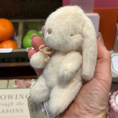 Small plush toy held in a hand with a blurred background