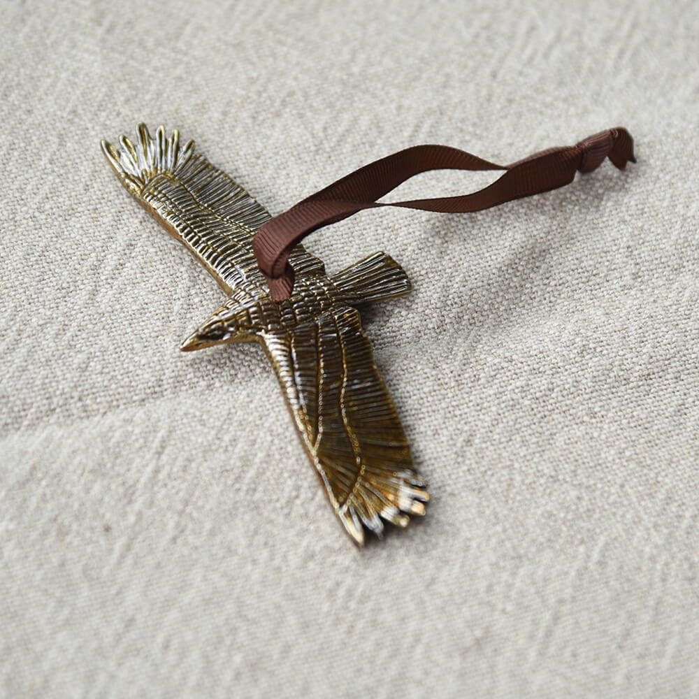 Bird decoration with hanging ribbon on a neutral background