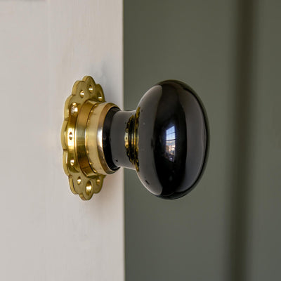 Black ceramic door knobs with petal edged backplate on cream door