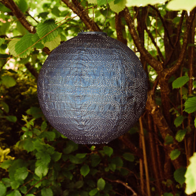 blue globe lantern hung in trees