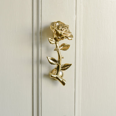 Single Brass Rose Door Knocker on cream door in the central panel
