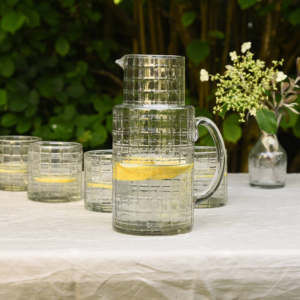 Chequered Glass hand bown jug with lemon water on outdoor dining table