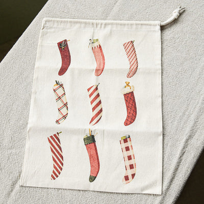 Decorative pouch with Christmas stocking designs on a gray surface