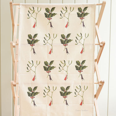 Tea towel with holly berry pattern on a wooden stand