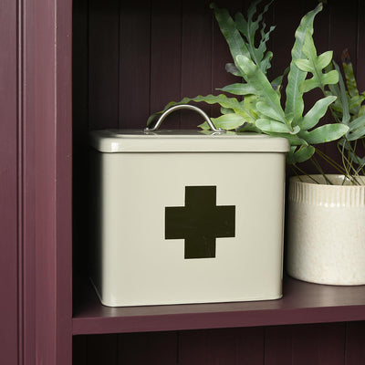 First aid tin on burgundy shelves