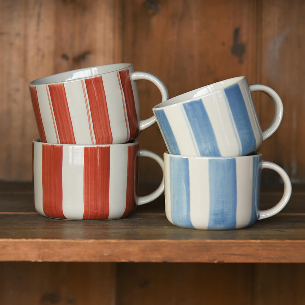 Two pairs of striped mugs on wooden shelf
