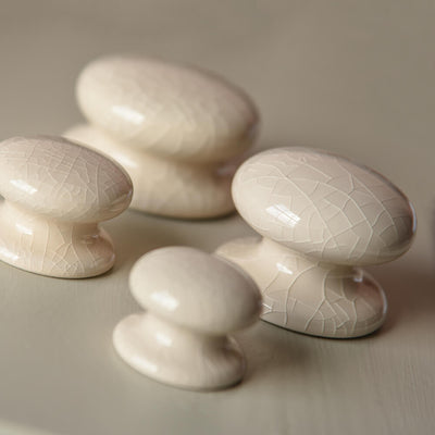 CReam ceramic cabient knobs in four sizes with an aged crackle glazed finish